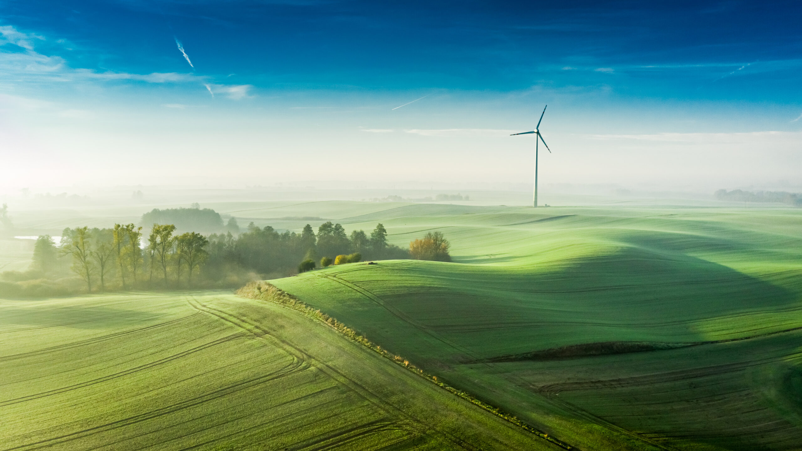 Stunning foggy wind turbine at sunrise, view from above
